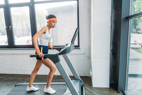 African american female athlete running on treadmill at gym — Stock Photo