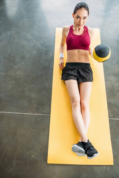 Young asian sportswoman with ball on fitness mat at gym — Stock Photo