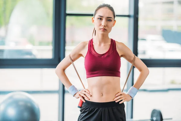 Porträt einer jungen asiatischen Sportlerin mit Springseil, die im Fitnessstudio in die Kamera blickt — Stockfoto