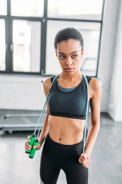 Porträt einer jungen afrikanisch-amerikanischen Sportlerin mit Springseil im Fitnessstudio — Stockfoto