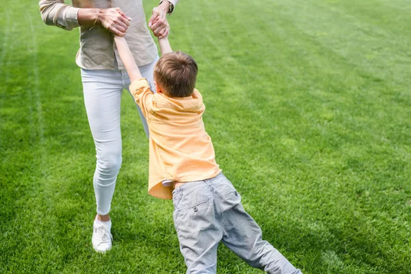 Schnappschuss von Mutter mit süßem kleinen Sohn beim gemeinsamen Spaß im Park — Stockfoto