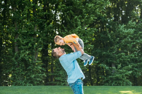 Glücklicher Vater mit entzückend lächelndem kleinen Sohn im Park — Stockfoto