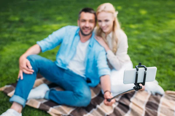 Foyer sélectif de heureux jeune couple prenant selfie avec smartphone au pique-nique — Photo de stock