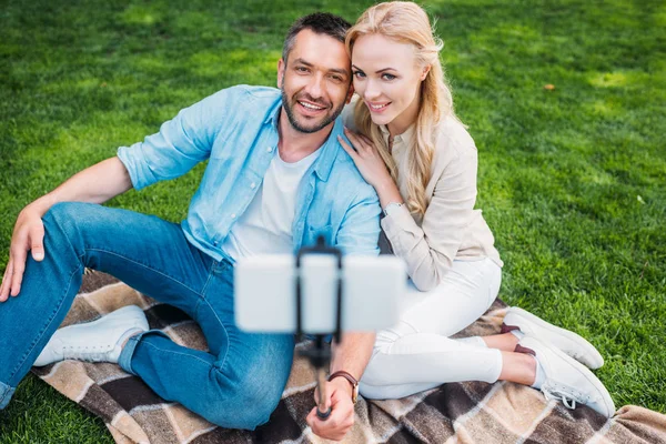 Feliz joven pareja tomando selfie con smartphone en el picnic - foto de stock