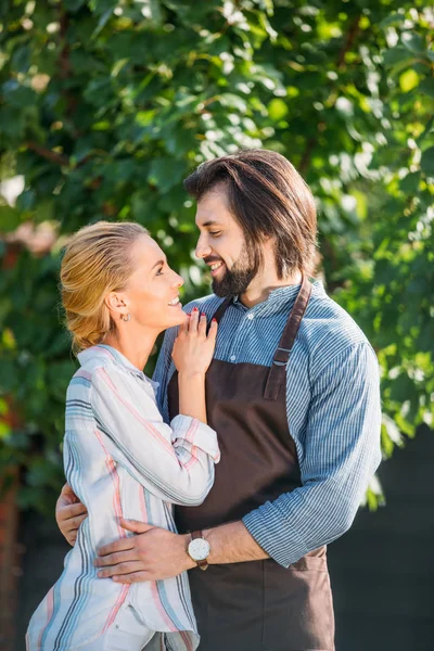 Счастливая пара обнимается и смотрит друг на друга на заднем дворе в летний день — стоковое фото