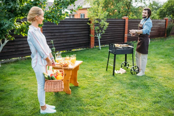 Couple having barbecue on backyard on summer day — Stock Photo
