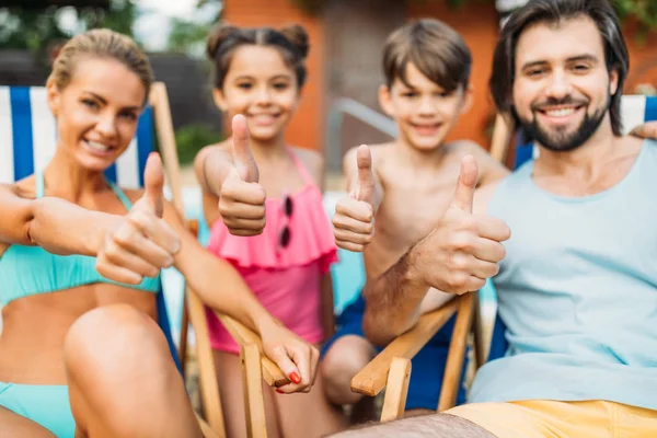 Foco seletivo da família mostrando polegares para cima ao passar o tempo perto da piscina no dia de verão — Fotografia de Stock