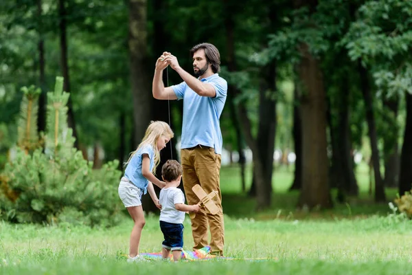 Pai e adoráveis crianças passando tempo juntos no parque — Fotografia de Stock