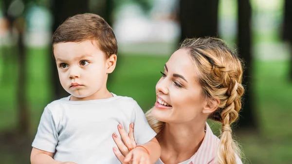 Primer plano retrato de feliz madre con hijo en el parque - foto de stock