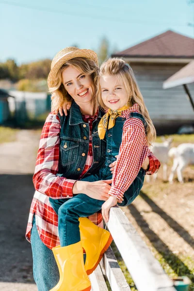 Glückliche erwachsene Bäuerin umarmt kleine Tochter auf Bauernhof — Stockfoto