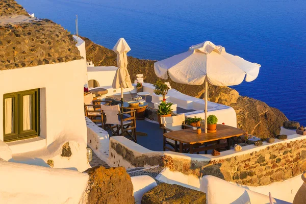 Restaurant table and chairs in sunrise light, Santorini island, Greece