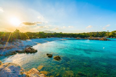 Spiaggia Capriccioli, günbatımında Emerald Sahili plajı, Doğu Sardunya Adası, İtalya