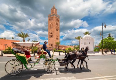 Marakeş, Fas 'taki Koutoubia Camii' nin önünde yolcu taşıyan at arabası.