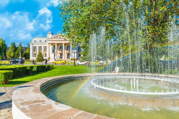 Arka planda Iasi, Moldavya Ulusal Opera Tiyatrosu, Romanya 'da gökkuşağı bulunan Artesya çeşmesi