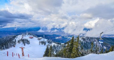 Romanya 'nın Brasov kentinde kayak pistleri ve teleferikli Postavaru dağının tepesinden manzara