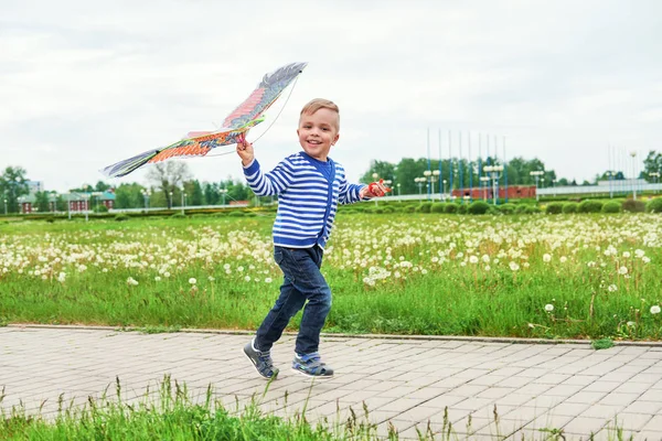 Šťastný chlapec usmívající se běží přes park s pouštění. Kavkazská dítěti zábavné hrát venku na letní nebo jarní den. Radostné dětství. Lifestyle.Attractive dítě aktivně volný čas na ulici. — Stock fotografie