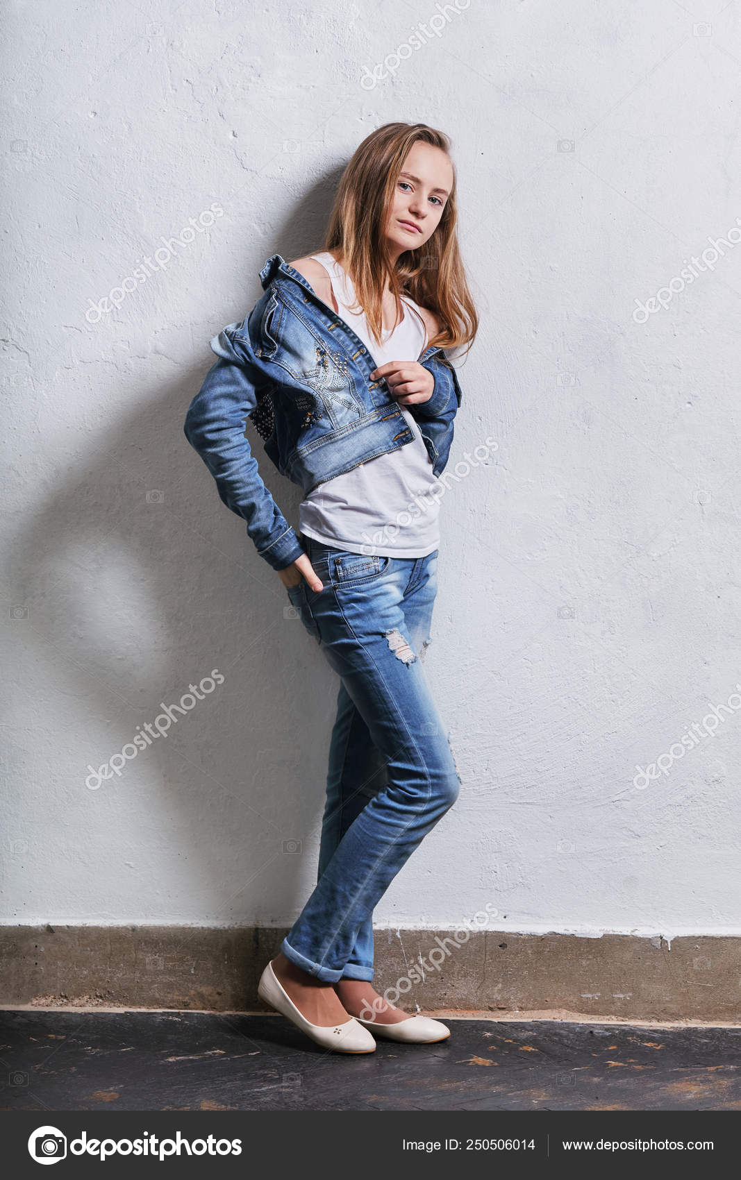 Chica adolescente de moda de pie apoyado contra una pared de hormigon blanco. Mujer joven caucasica