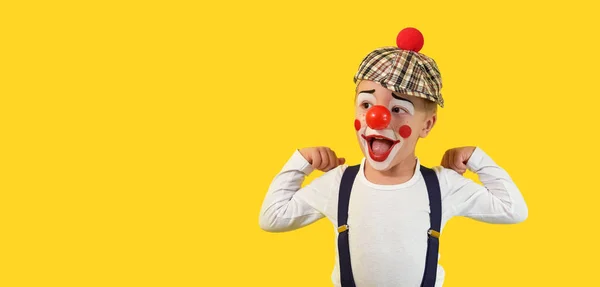 Portrait funny child clown.Cheerful boy,costume,red nose,makeup.Emotional face little comic kid.Happy baby isolated yellow background. concept birthday, holiday, humor. studio,blank,banner,copy space — Stock Photo, Image