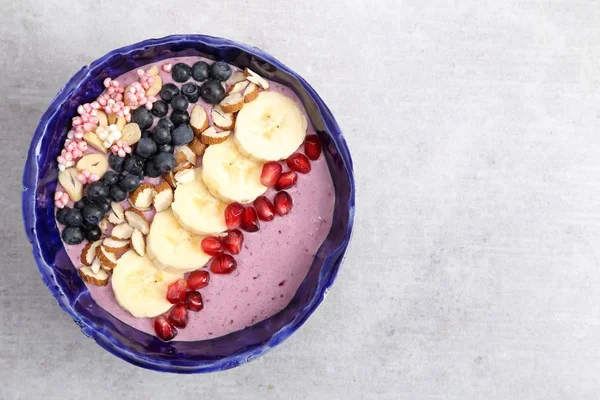 Sağlıklı blueberry smoothie kaseyle bannan, el bombası, badem, darı bulamaç.