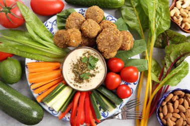 Renkli sebze, marul, falafels ve humus ahşap arka plan üzerinde bir plaka üzerinde.