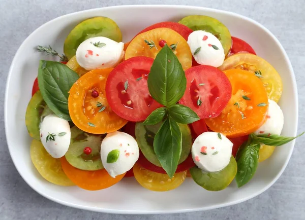 Salad of colorful tomatoes, mozzarella cheese and basil. Top view.