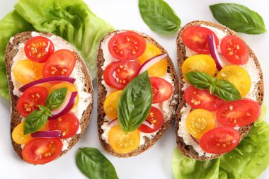 Peynir, renkli domates, fesleğen ve soğan ile sandviçler. Üstten görünüm.