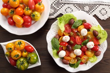 Renkli domates mozzarella peynir, zeytin, kapari ve fesleğen salata. Üstten görünüm.