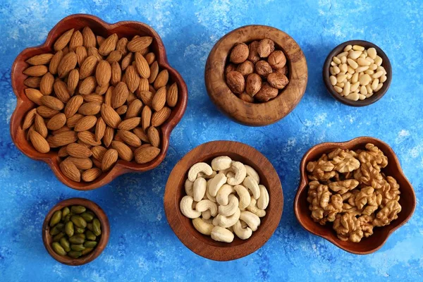 Different Types Nuts Wooden Bowls Blue Background Top View — Stock Photo, Image