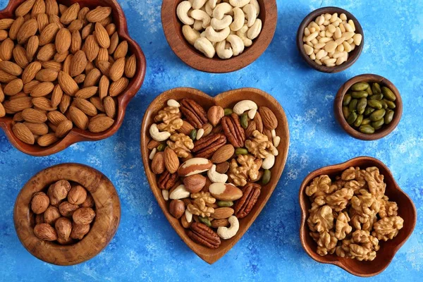 Different Types Nuts Wooden Bowls Blue Background Top View — Stock Photo, Image