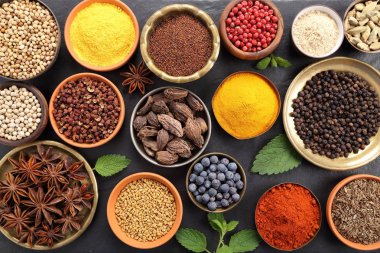 Renkli ve aromatik bitki ve baharat siyah seramik zemin. Üstten görünüm.