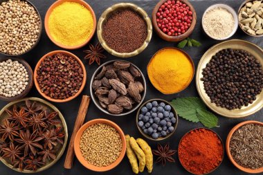 Renkli ve aromatik bitki ve baharat siyah seramik zemin. Üstten görünüm.