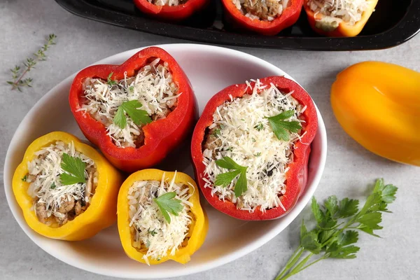 Stuffed peppers with rice, meat and cheese in a baking dish.