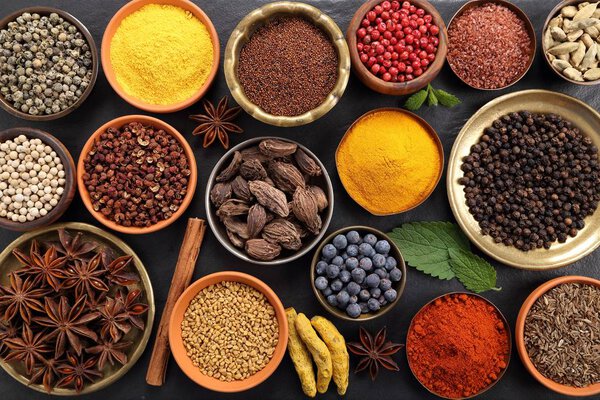 Красочные и ароматные травы и специи на черном керамическом фоне. Вид сверху
.