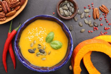 Siyah arka plan üzerine bir kapta balkabağı çorbası. Üstten görünüm.