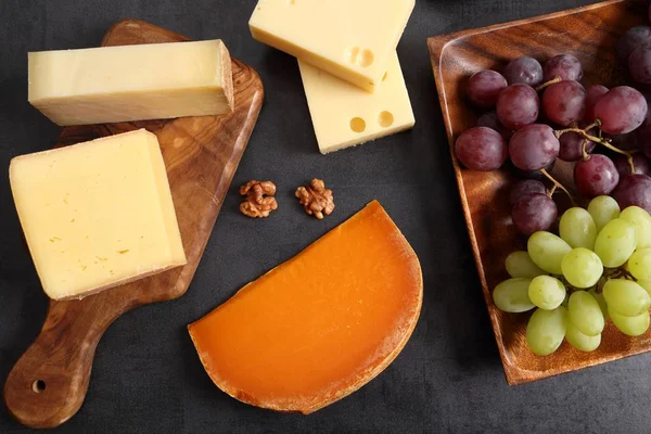 Tahta bir tahta üzerinde peynir farklı türleri. Fındık, zeytin, meyve gibi diğer atıştırmalıklar.