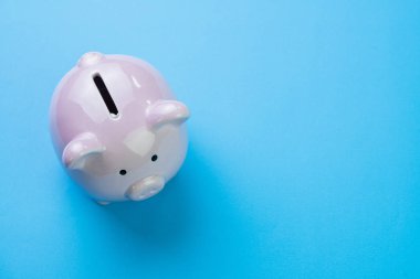 Mali, tasarruf, bütçe, maliyet veya yatırım kavramı, kopya alanı ile temiz mavi arka plan üzerinde beyaz mutlu kumbara.