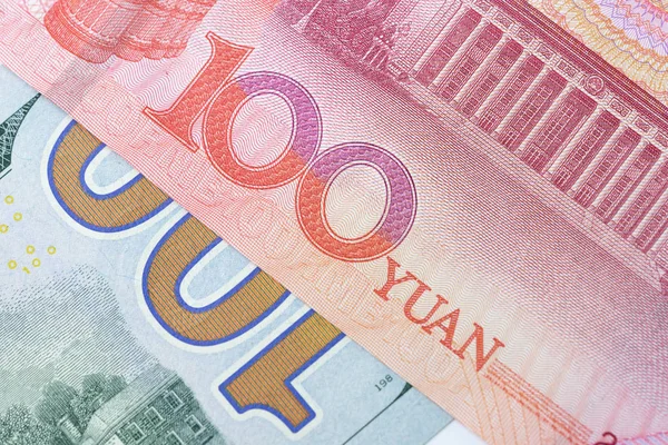 Закрыто 100 номеров банкнот в долларах США на красном 100 китайских юаней — стоковое фото
