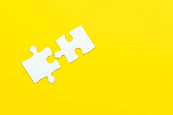 2 quebra-cabeça em fundo amarelo sólido usando como 2 importante — Fotografia de Stock