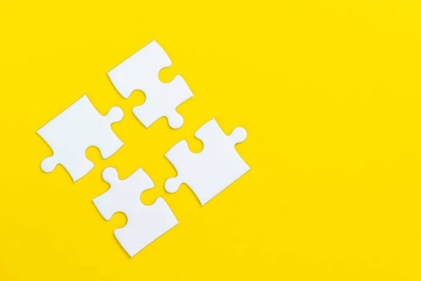 4 quebra-cabeça em fundo amarelo sólido usando como quatro importa — Fotografia de Stock