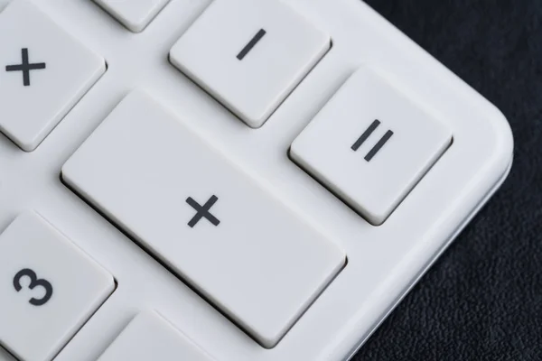 Closed up of white calculator buttons such as plus, minus, multi