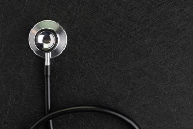 Polis ile koyu doku arka planda siyah kablo ile stetoskop