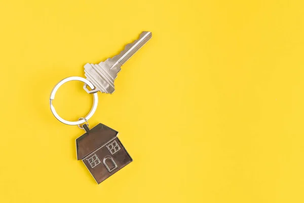 Hem nyckel med hus nyckelring eller nyckelring på solid gul bakgrun — Stockfoto