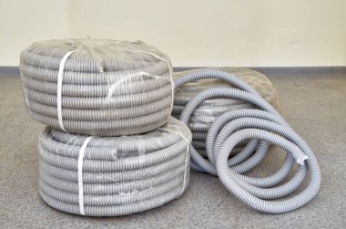 Gri endüstriyel oluklu esnek boru rulo. Nervürlü hortum veya boru Pvc. gri izolasyon kablolar için.