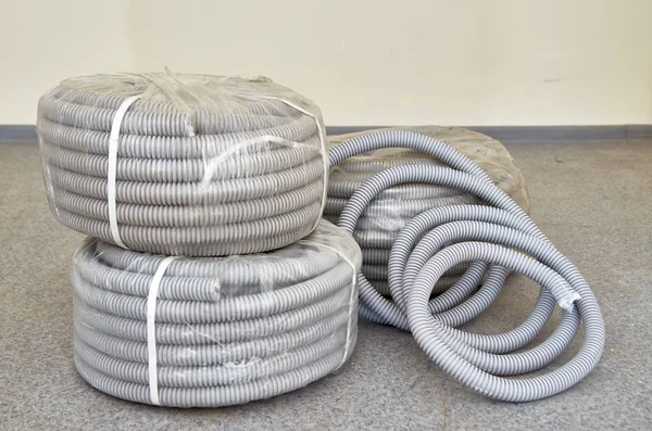 Roll of gray industrial corrugated flexible pipe. Ribbed hose or pipe PVC. Gray insulation for cables.