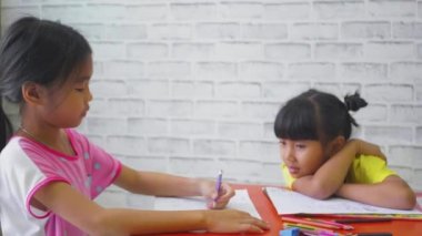 Evdeki oturma odasında Asyalı çocukların çizdiği resim, günlük yaşam tarzı videosu..