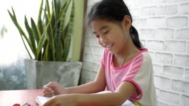 Oturma odasında ödev yapan Asyalı kız..