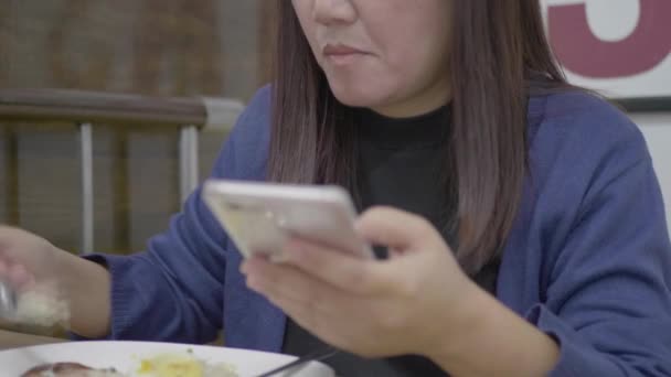 Mujer Asiática Usando Smartphone Comiendo — Vídeos de Stock