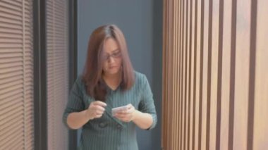 İç İşleri Bakanlığı 'nda Asyalı Kadın Yürüyüşü ve Elleri Akıllı Telefon Kullanıyor.