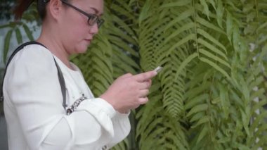 Parkta cep telefonu kullanan kadın elini kapat..