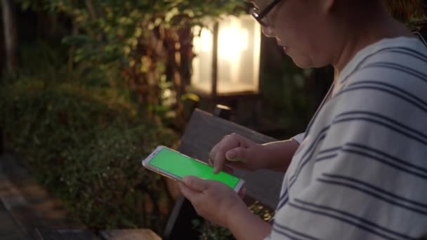 Asiatin Mit Grünem Bildschirm Smartphone Abend Garten — Stockvideo